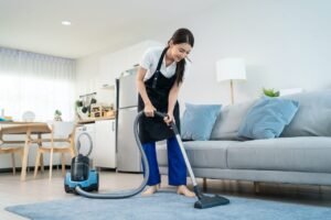 asian cleaning service woman worker cleaning in living room at home